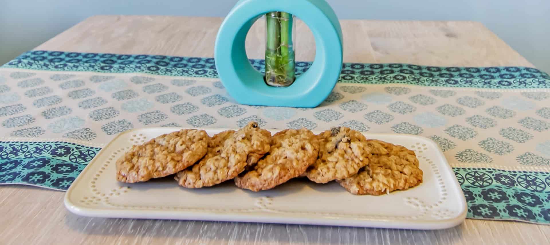 White platter with oatmeal raisin cookies on top of table with navy and turquoise table runner