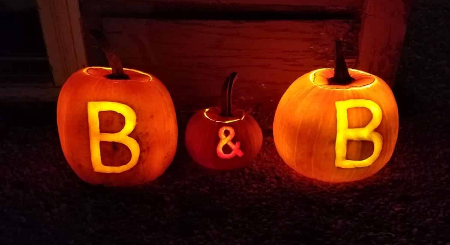 Halloween pumpkins lighted up at night with the letters B & B